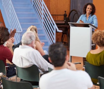 woman-at-podium-chairing-neighborhood-meeting-in-c-2023-11-27-05-18-56-utc.jpg