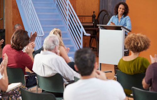 woman-at-podium-chairing-neighborhood-meeting-in-c-2023-11-27-05-18-56-utc.jpg