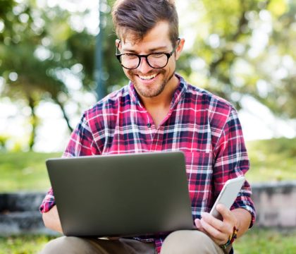 young-man-smartphone-browsing-laptop-concept-2023-11-27-04-59-31-utc.jpg